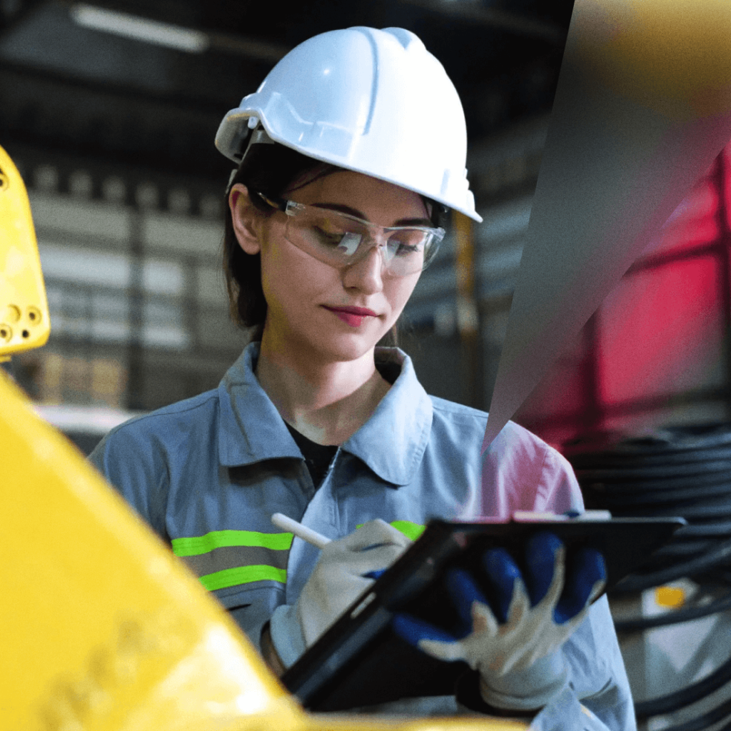 femme en tenue de sécurité utilisant une tablette dans un environnement industriel