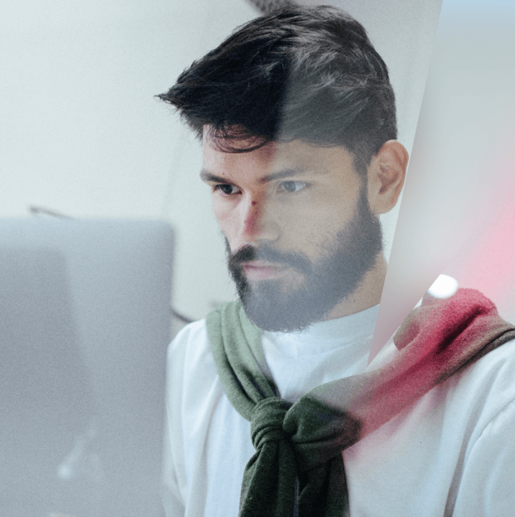 homme barbu travaillant sur un ordinateur pull vert noué sur les épaules